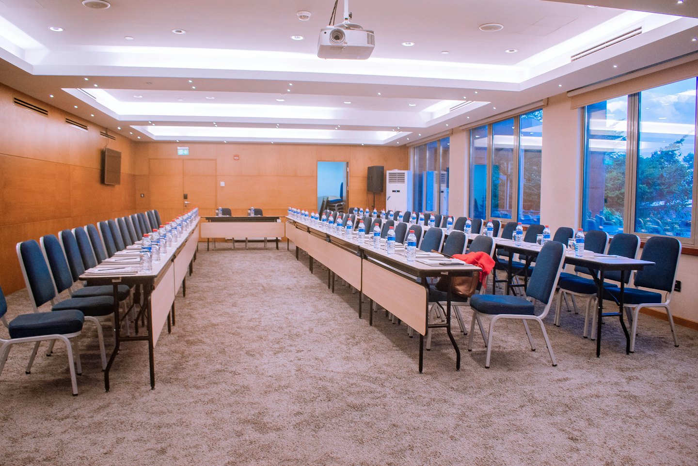 Empty conference room prepared with tables and chairs for a meeting.